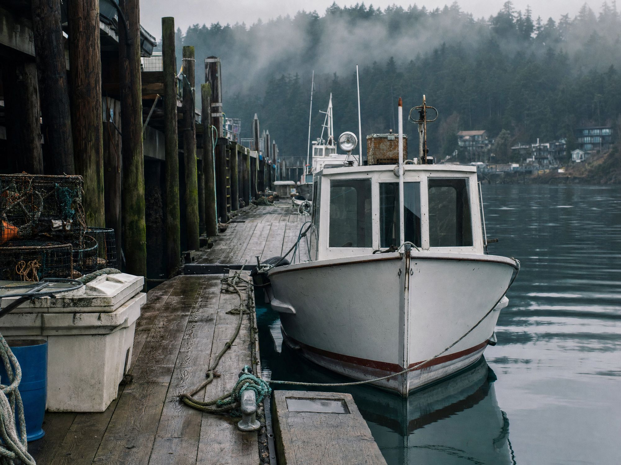 Osprey, a modest cabin boat tied to a working wooden dock.